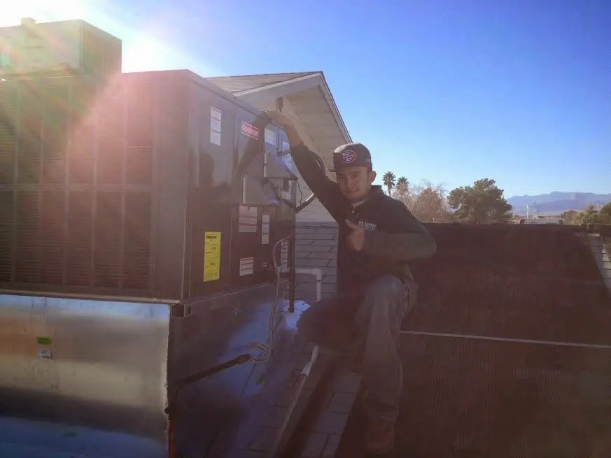 HVAC technician performing Boiler Repair on a rooftop unit in Moline